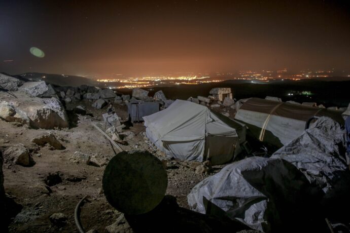 Tents for homeless in stony terrain at night, Idlib, Idlib Governorate, Syria.
